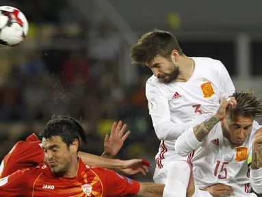 Pemain Spanyol, Gerard Pique menghalau bola dari kejaran pemain Makedonia pada laga kualifikasi Piala Dunia 2018 grup G di Philip II National Stadium, Skopje, MaKedonia, (11/6/2017). (AP/Boris Grdanoski)