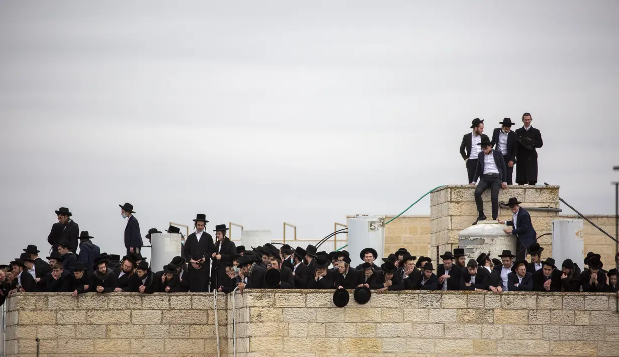 Ultra-Ortodoks Yahudi berpartisipasi dalam pemakaman rabi terkemuka Meshulam Soloveitchik, di Yerusalem, Minggu (31/1/2021). Meshulam Dovid Soloveitchik tertular virus corona tahun lalu, dan kondisinya dilaporkan memburuk secara dramatis selama akhir pekan. (AP Photo/Ariel Schalit)