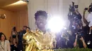 Penampilan rapper Lil Nas X menghadiri The 2021 Met Gala Celebrating In America: A Lexicon Of Fashion di Metropolitan Museum of Art, New York City, Senin (13/9/2021). Lil Nas X yang hadir di Met Gala 2021 dengan penuh totalitas tampil menggunakan 3 busana sekaligus. (Evan Agostini/Invision/AP)