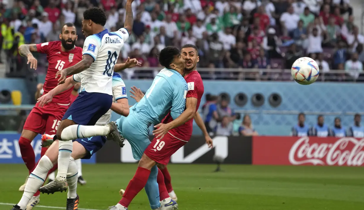 Kiper timnas Iran Alireza Beiranvand bertabrakan dengan rekan setimnya Majid Hosseini saat pertandingan sepak bola grup B Piala Dunia Qatar 2022 antara Inggris dan Iran di Stadion Internasional Khalifa, Doha, Qatar, Senin (21/11/2022). Saat Kiper Beiranvand dan Majid mencoba menghalau bola, keduanya justru bertabrakan. (AP Photo/Alessandra Tarantino)