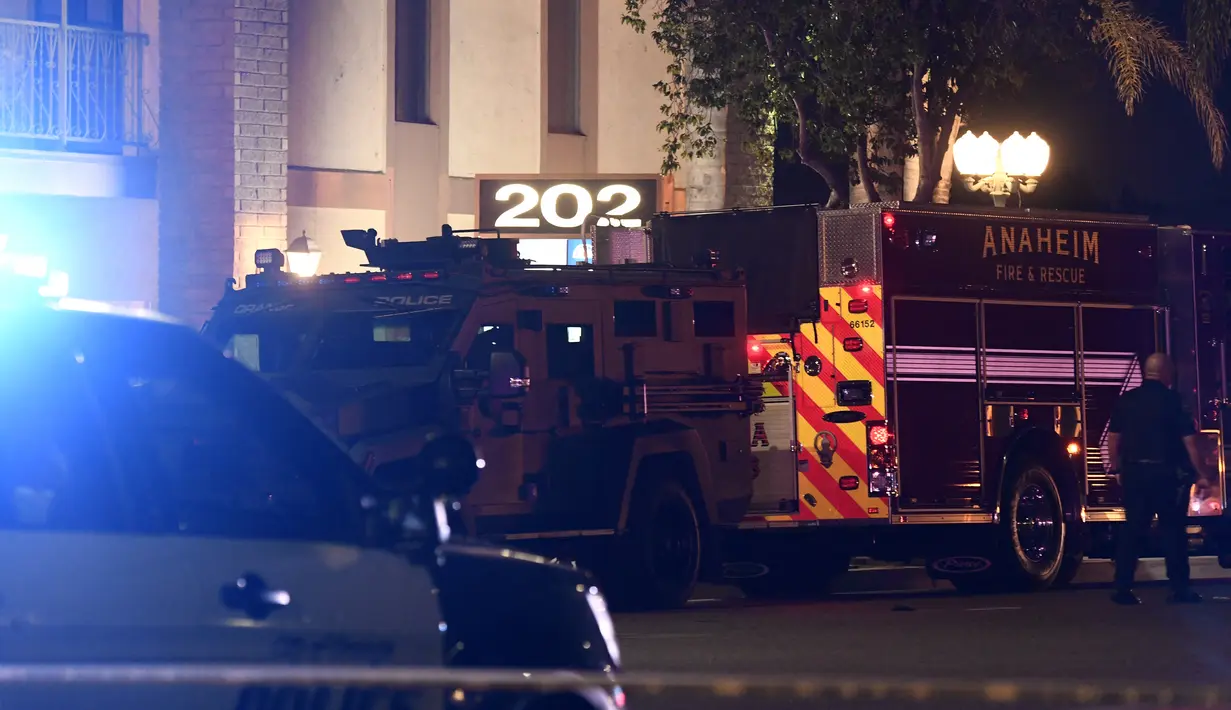 Seorang petugas polisi berdiri di luar gedung perkantoran di mana beberapa orang tewas dalam penembakan di Orange, California (31/3/2021).  Tersangka ditahan dan juga dibawa ke rumah sakit. (AFP/Patrick T. Fallon)