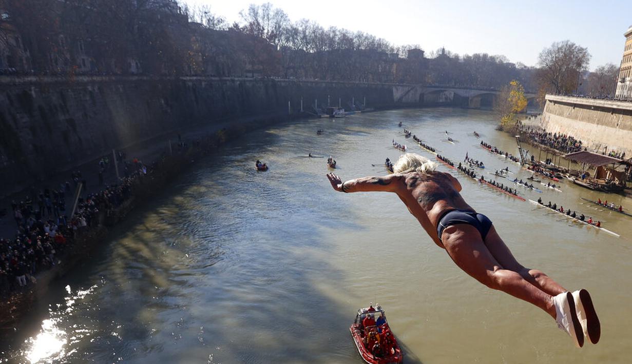 Maurizio Palmulli dari Italia melompat ke Sungai Tiber dari Jembatan Cavour setinggi 18 meter (59 kaki) untuk merayakan Tahun Baru di Roma, 1 Januari 2022. (AP Photo/Riccardo De Luca)