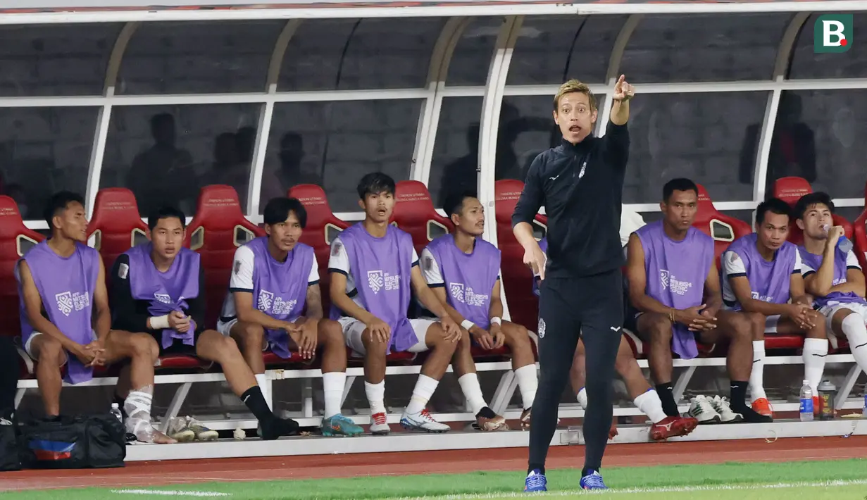 Manajer Timnas Kamboja, Keisuke Honda, tampak sibuk saat Kamboja melawan Timnas Indonesia pada laga Grup A Piala AFF 2022. (Bola.com/M iqbal Ichsan)