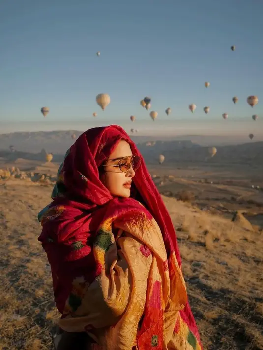 Gaya modis dan glamornya saat di Cappadocia pun diperlengkap dengan aksesori berupa  kacamata orange dan syal warna merah, makin chic! (Instagram/ashanty_ash).