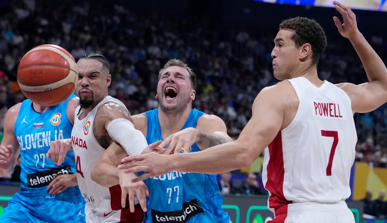 Pemain timnas basket Slovenia Luka Doncic (tengah) kehilangan bola saat diadang dua pebasket Kanada Dillon Brooks dan Dwight Powell pada pertandingan perempat final Piala Dunia Bola Basket di Manila, Filipina, Rabu, 6 September 2023. (AP Photo/Michael Conroy)
