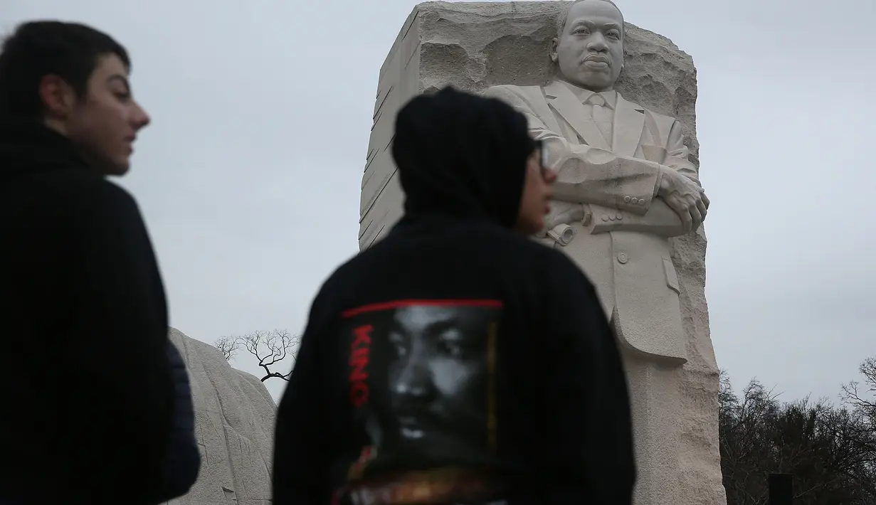 Sejumlah orang berkumpul dan berdoa di depan Patung Martin Luther King Jr, Washington DC, AS, Senin (16/1). Di Amerika Serikat, Senin pada Minggu ketiga diperingati sebagai 'Hari Martin Luther King Jr'. (Joe Raedle / Getty Images / AFP)