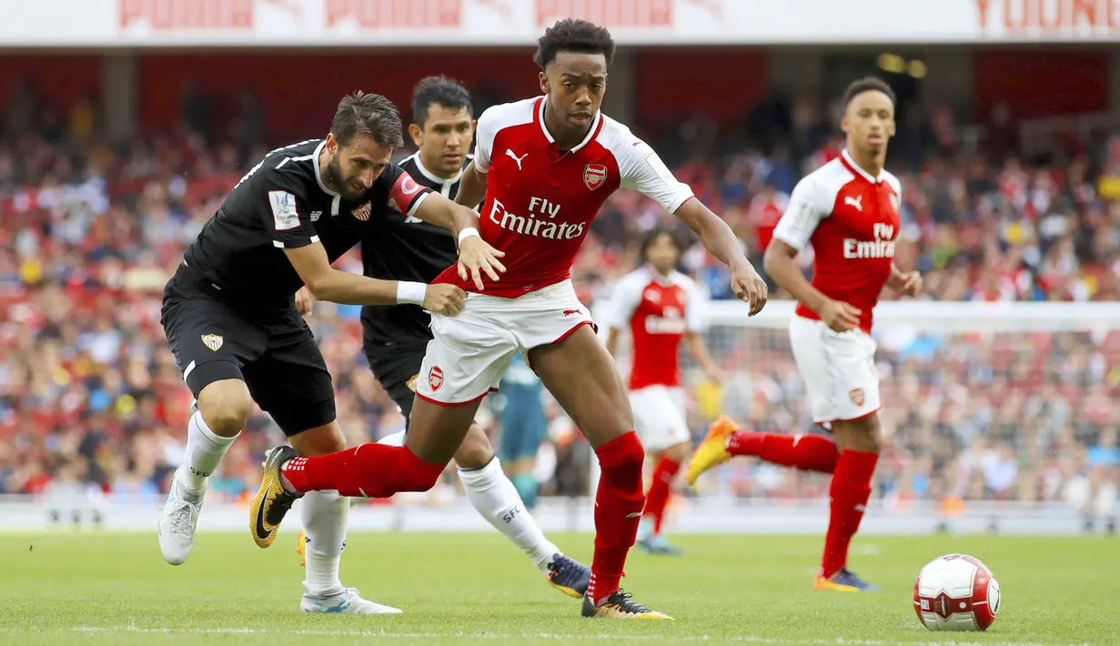 Bek Sevilla, Nicolas Pareja, berusaha merebut bola dari pemain Arsenal, Joe Willock pada laga turnamen Piala Emirates yang berlangsung di Stadion Emirates, Minggu (30/7/2017). Arsenal takluk 1-2 dari Sevilla. (AP/John Walton)