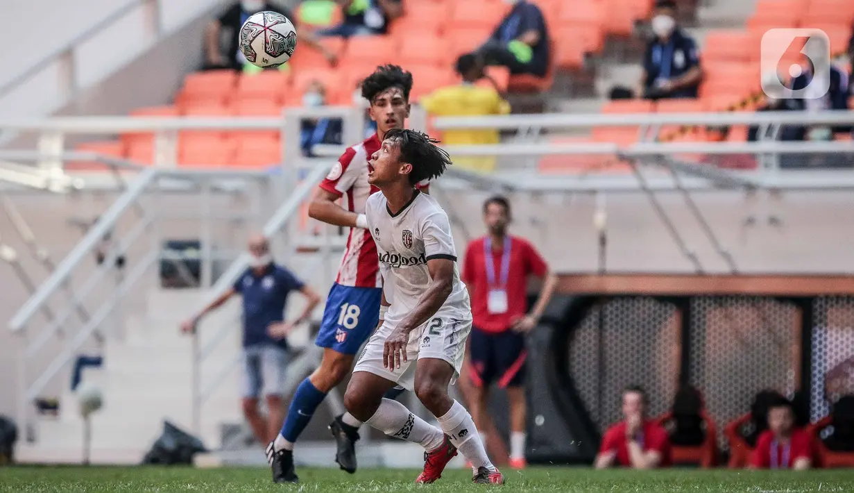 Pemain Atletico Madrid U-18 Jacobo De Oro Lorenzo berebut bola dengan pemain Bali United U-18 Reyner Immanuelo pada laga perdana International Youth Championship (IYC) 2021 di Jakarta International Stadium (JIS), Rabu (13/4/2022). Atletico Madrid U-18 menang 5-0. (Liputan6.com/Faizal Fanani)