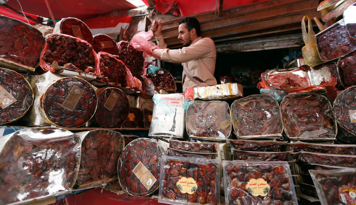 Pedagang menyiapkan kurma selama bulan suci Ramadan di sebuah pasar di ibukota Sanaa, Yaman (22/5). (AFP Photo/Mohammed Huwais)
