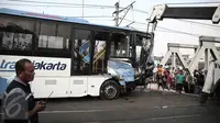 Alat berat mengevakuasi bus transjakarta yang mengalami kecelakaan dengan kereta api di perlintasan Jalan Mangga Dua, Jakarta, Kamis (19/5). Kecelakaan itu melibatkan bus Transjakarta, mobil Avanza dan kereta Senja Utama Solo. (Liputan6.com/Faizal Fanani)