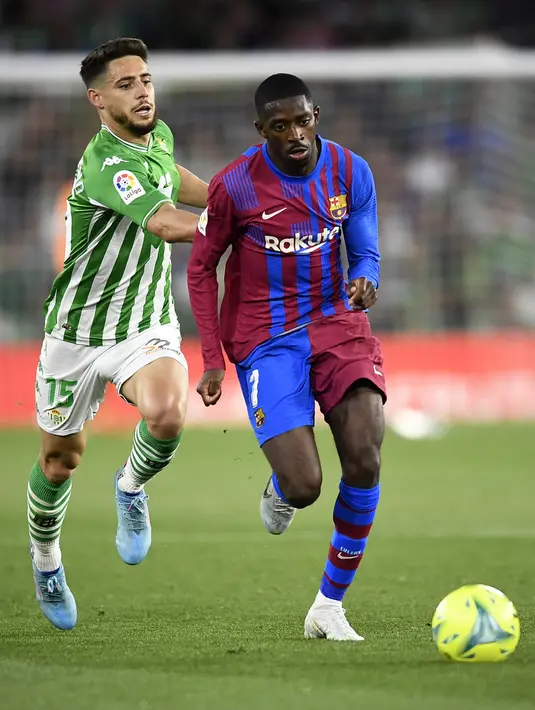 <p>Pemain Barcelona Ousmane Dembele (kanan) berebut bola dengan pemain Real Betis Alex Moreno pada pertandingan sepak bola La Liga Spanyol di Stadion Benito Villamarin, Seville, Spanyol, 7 Mei 2022. Barcelona menang 2-1. (AP Photo/Jose Breton)</p>