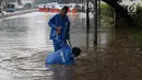 Petugas berusaha memperbaiki saluran air guna mengurangi banjir yang  merendam kawasan Gambir, Jakarta, Kamis (15/2). (iputan6.com/Immanuel Antonius)