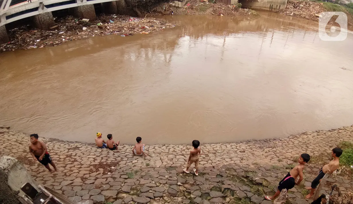 Sejumlah anak bermain di Bantaran sungai Kanal Banjir Barat, Tanah Abang, Jakarta, Sabtu (4/1/2020). Minimnya pengawasan  membuat anak-anak kerap bermain di tempat berbahaya yang berpotensi mengancam keselamatan mereka. (Liputan6.com/Angga Yuniar)