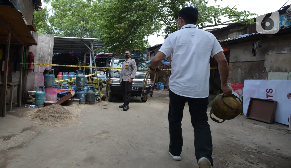 Polisi saat mengamankan barang bukti gas subsidi di Meruya Utara, Jakarta Barat, Selasa (6/4/2021). Polisi juga mengamankan dua tersangka yakni DF dan T menjual hasil gas oplosan berisi 12 Kg seharga Rp140 ribu. (merdeka.com/Imam Buhori)