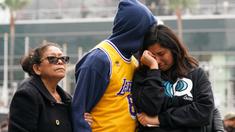 Fans LA Lakers tampak sedih usai Kobe Bryant meninggal dunia di Staples Center, Minggu (26/1/2020). Legenda basket NBA itu wafat dalam kecelakaan helikopter di Calabasas, California. (AFP/Rachel Luna)