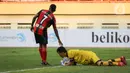 Kiper Persela Dwi Kuswanto (bawah) berusaha menyelamatkan bola dari gelandang Persipura Elisa Yahya Basna dalam laga pekan kedua BRI Liga 1 2021/2022 antara Persela Lamongan melawan Persipura Jayapura di Stadion Wibawa Mukti, Cikarang, Jumat (10/9/2021). (Bola.com/Bagaskara Lazuardi)