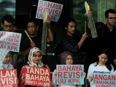 Aksi sejumlah masyarakat sipil membawa pentungan sebagai tanda peringatan terkait revisi uu KPK, Jakarta, Selasa (16/2/2016). Aksi tersebut menolak akan di sahkannya uu revisi oleh DPR. (Liputan6.com/Helmi Afandi)