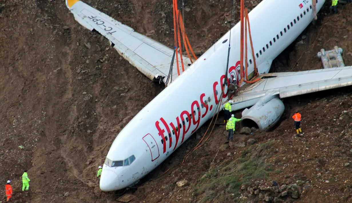 Petugas menggunakan crane untuk mengevakuasi pesawat Boeing 737-800 dari maskapai Pegasus Airlines yang nyaris terperosok ke dalam laut di bandara Trabzon, Turki (18/1). (AP Photo / Turkay Albayak)