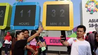 Warga swafoto dan selfie dengan latar layar Countdown Asian Games 2018 saat Car Free Day di Bundaran HI, Jakarta, Minggu, (10/09). Hitung mundur pelaksanaan Asian Games 2018 kini telah memasuki H - 342. (Liputan6.com/Fery Pradolo)