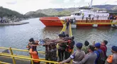 Petugas penyelamat, personel militer, dan polisi membawa penumpang yang telah dievakuasi menggunakan tandu turun dari kapal pencarian dan penyelamatan di Pelabuhan Lembar, Lombok Barat, Rabu, 12 Agustus 2026. (AFP)