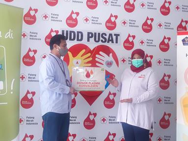 Kepala Unit Usaha Syariah ACC Wisnu Wardhana (kiri) menyerahkan secara simbolis bantuan donor plasma kepada Kepala Unit Donor Darah PMI Ria Syafitri (kanan) di Jakarta Kamis (04/02/2021). (Liputan6.com/Pool)