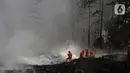 Petugas Pemadam Kebakaran Kabupaten Bogor memadamkan api di lapak ban bekas, Desa Bojong Nangka, Gunung Putri, Kamis (22/4/2021). Banyaknya bahan yang mudah terbakar dan sumber api yang berasal dari bawah tumpukan ban membuat  api di lokasi belum juga padam. (Liputan6.com/Herman Zakharia)