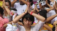 Sejumlah umat Hindu melakukan sembahyang dalam upacara Tawur Kesanga di Pura Aditya Jaya, Rawamangun, Jakarta, Jumat (16/3). Upacara ini bertujuan memohon pada Tuhan Yang Maha Esa untuk kedamaian alam dan lingkungan. (Liputan6.com/Arya Manggala)