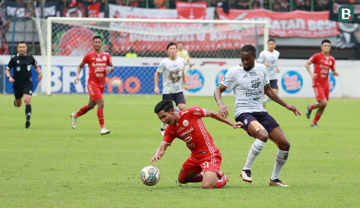 Pemain Rans Nusantara FC, Yanis Mbombo berusaha melewati pemain Persija Jakarta, Firza Andika pada laga BRI Liga 1 di Stadion Patriot Candrabhaga, Bekasi, Jumat (3/2/2023). Rans Nusantara FC kalah dengan skor 1-3. (Bola.com/M Iqbal Ichsan)