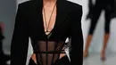 Model Bella Hadid mengenakan membawakan koleksi Spring 2020 dari Mugler dalam gelaran Paris Fashion Week, Rabu (25/9/2019). Bella Hadid tampil dalam balutan lingerie hitam transparan yang dipadukan dengan celana thong. (AP Photo/Francois Mori)