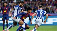 Duje Caleta-Car (kiri) menghadang Dro Fernandez (tengah) dalam pertandingan La Liga Spanyol antara Barcelona dan Real Sociedad di Stadion Olimpiade Lluis Companys, Barcelona, Spanyol, Minggu, 28 September 2025. (AP Photo/Joan Monfort)