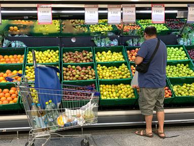 Seorang pria membeli buah di sebuah supermarket di Buenos Aires, Argentina, Rabu (15/3/2023). Tingkat inflasi Argentina telah melonjak melampaui 100 persen untuk pertama kalinya sejak akhir hiperinflasi di awal tahun 90-an. (Photo by STRINGER / AFP)