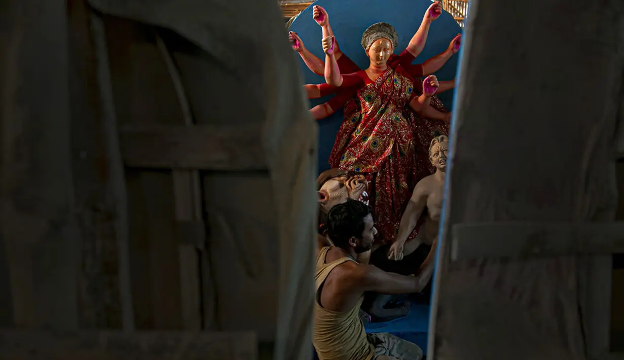 Seniman membuat patung Dewi Durga jelang Festival Durga Puja di Gauhati, India, Jumat (16/10/2020). Para pejabat kesehatan memperingatkan tentang potensi penyebaran COVID-19 selama musim festival keagamaan dengan pertemuan besar di kuil dan distrik perbelanjaan. (AP Photo/Anupam Nath)