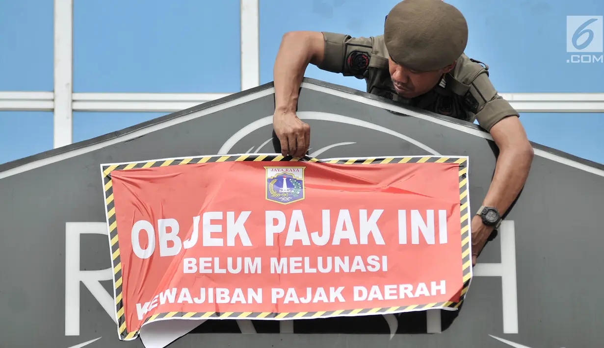 Petugas Satpol PP memasang stiker tunggak pajak di salah satu kios Green Pramuka Square Mall, Jakarta, Rabu (7/11). Kegiatan ini dilakukan guna memberi sanksi sosial ke pemilik untuk segera menyelesaikan penunggakan pajak. (Merdeka.com/Iqbal S. Nugroho)