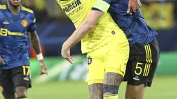Gelandang Villarreal Etienne Capoue berebut bola dengan bek Manchester United (MU) Harry Maguire pada matchday kelima Grup F Liga Champions di Ceramica stadium, Rabu (24/11/2021) dini hari WIB. MU sukses meraih kemenangan 2-0 di kandang Villarreal. (AP Photo/Alberto Saiz)