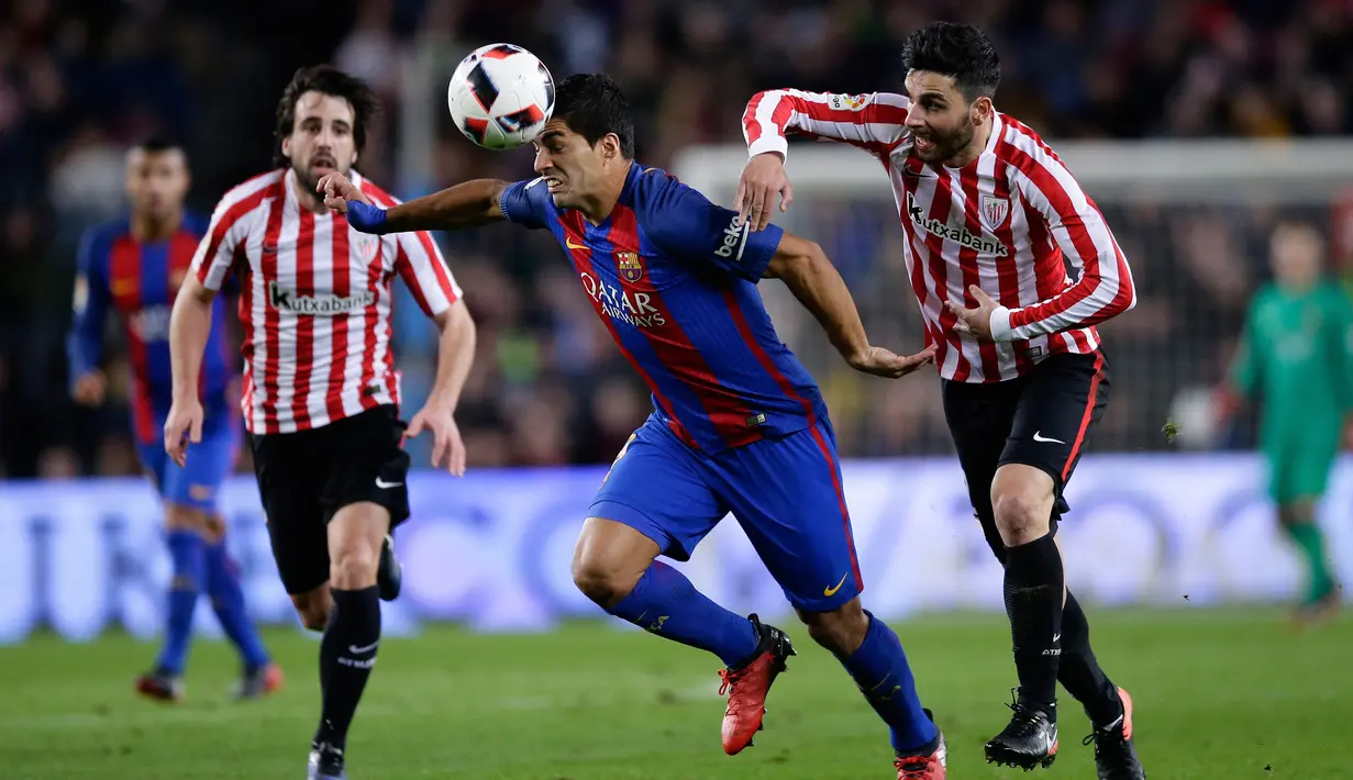 Penyerang Barcelona, Luis Suarez berusaha melewati pemain Athletic Bilbao saat pertandingan Piala Raja di Camp Nou, Barcelona, Kamis (12/1). Barcelona menang 3-1 atas Bilbao. (AP/Manu Fernandez)