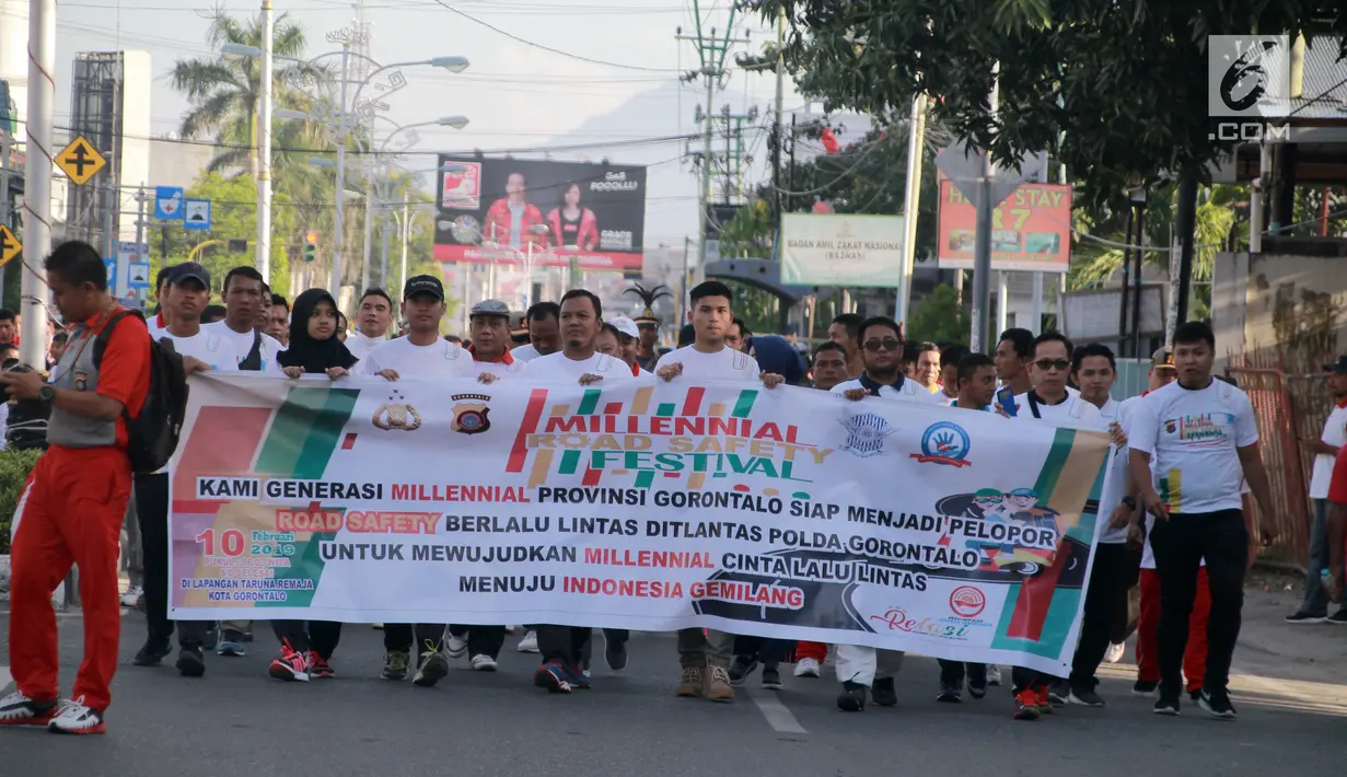 Peserta membawa spanduk mengikuti kegiatan Millenial Road Safety Festival Gorontalo, Minggu (10/2). Kegiatan dilaksanakan sebagai upaya memberikan pengetahuan kalangan millenial di Gorontalo untuk tertib berlalulintas.(Liputan6.com/Rahmad Arfandi Ibrahim)