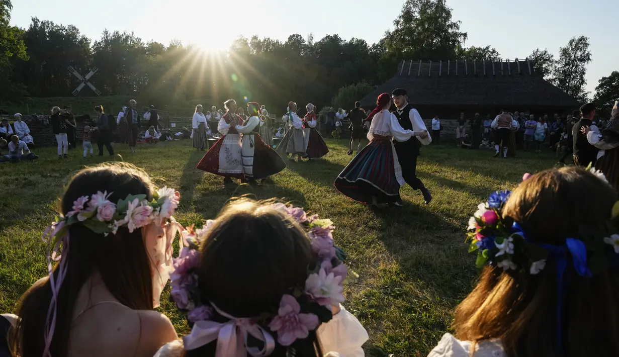 Orang-orang mengenakan pakaian tradisional menari selama perayaan Midsummer Day di Open Air Museum di Tallinn, Estonia, Jumat, 23 Juni 2023. (AP Photo/Pavel Golovkin)