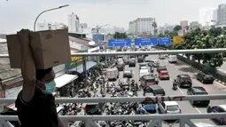 Warga membawa kardus berisi masker yang dibeli di Pasar Pramuka, Jakarta, Senin (16/3/2020). Pasar Pramuka diserbu pembeli yang mencari masker guna mengantisipasi virus Corona, membuat sebagian badan jalan dimanfaatkan sebagai parkiran sehingga menyebabkan kemacetan. (merdeka.com/Iqbal Nugroho)