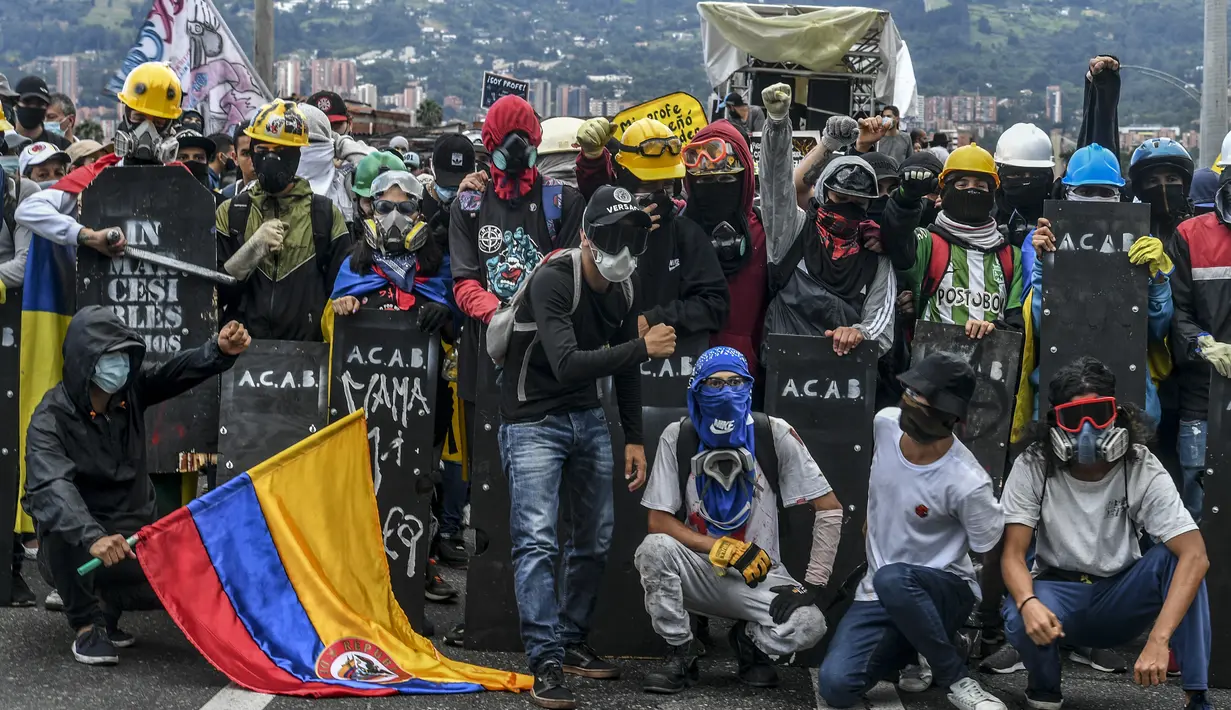Demonstran berpose untuk foto selama protes baru melawan pemerintah Presiden Kolombia Ivan Duque, di Medellin, Kolombia (26/5/2021).  Demonstrasi terus berlanjut dalam menghadapi tindakan keras polisi yang telah menuai kecaman internasional. (AFP/Joaquin Sarmiento)