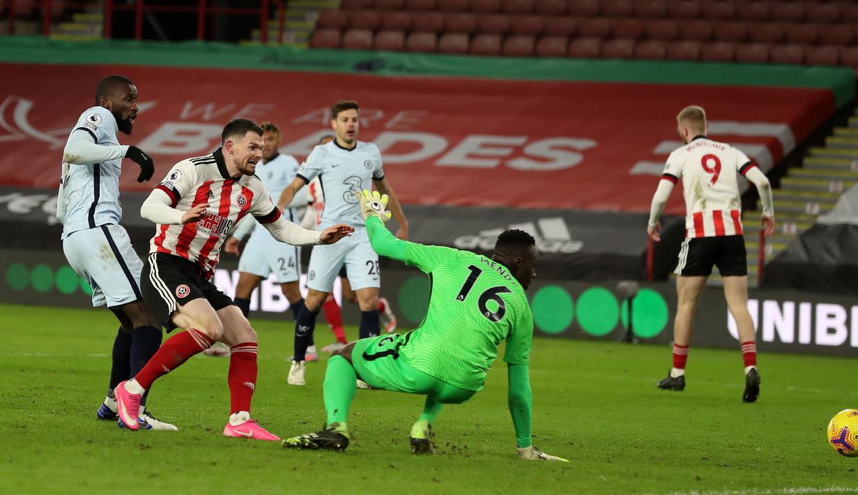 Bek Chelsea, Antonio Rudiger (kiri) melakukan gol bunuh diri dalam laga lanjutan Liga Inggris 2020/21 pekan ke-23 melawan Sheffield United di Bramall Lane, Minggu (7/2/2021). Chelsea menang 2-1 atas Sheffield United. (AFP/Lee Smith/Pool)
