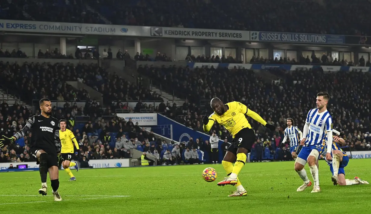 Pemain Chelsea Romelu Lukaku (tengah) melakukan tendangan saat melawan Brighton and Hove Albion pada pertandingan sepak bola Liga Inggris di American Express Community Stadium, Brighton, Inggris, 18 Januari 2022. Pertandingan berakhir 1-1. (Glyn KIRK/AFP)