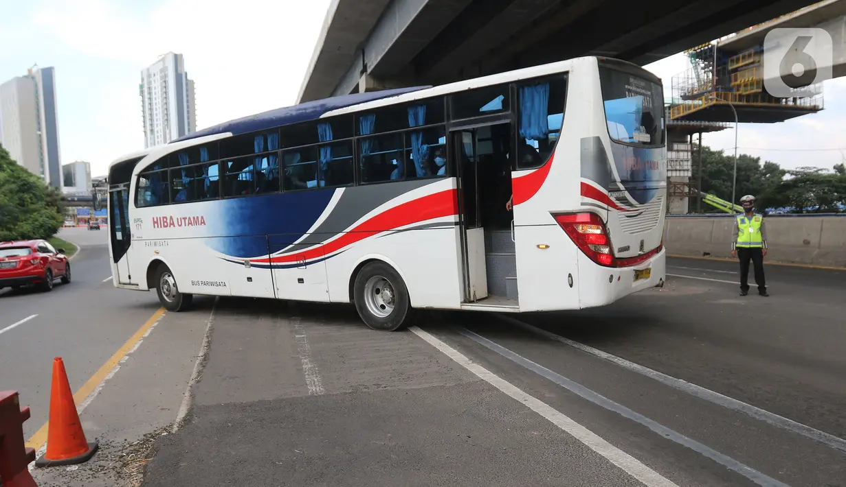 Polisi memeriksa kendaraan di Pos Penyekatan Jalur Mudik, Gerbang Tol Cikarang Barat, Bekasi, Rabu (20/5/2020). Sejak 24 April sampai 19 Mei 2020, Ditlantas Polda Metro Jaya telah memutarbalikkan 20.972 kendaraan mudik Lebaran yang hendak meninggalkan Jabodetabek. (Liputan6.com/Herman Zakharia)