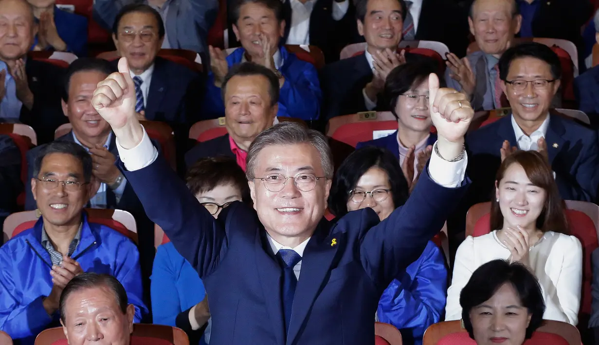 Kandidat Presiden Korsel, Moon Jae-in mengangkat tangan usai hasil hitung cepat memperlihatkan dia unggul dibanding calon lainnya di Seoul, Selasa (9/5). Calon Partai Demokrat itu menang telak dengan mengantongi 41,4 persen suara (AP Photo/Ahn Young-joon)