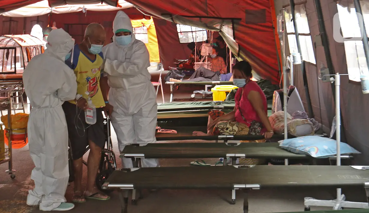 Petugas medis membawa pasien COVID-19 menuju tenda darurat di RSUD Bekasi, Rabu (23/6/2021). Tenda darurat didirikan sebagai upaya menambah ruang IGD yang dapat menampung 30 pasien menyusul ruangan di rumah sakit sudah penuh akibat lonjakan kasus Covid-19. (Liputan6.com/Herman Zakharia)