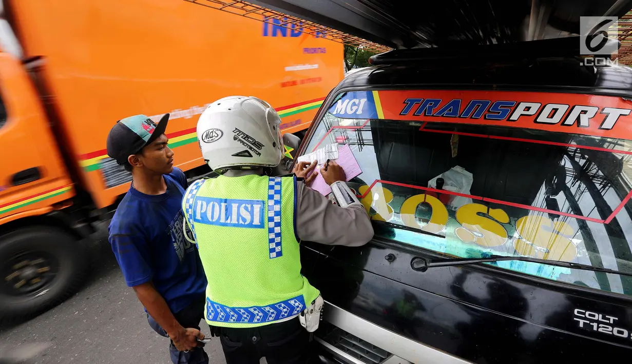 Petugas kepolisian memberi surat tilang ke pengendara saat Operasi Zebra Jaya 2017 di Daan Mogot, Jakarta, Selasa (7/11). Operasi Zebra yang digelar 1 November- 14 Desember 2017 tersebut secara serentak dilakukan se-Indonesia. (Liputan6.com/Johan Tallo)