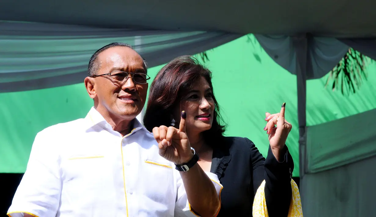 Aburizal Bakrie bersama istri Tatty Bakrie menunjukkan jari kelingking yang usai mencoblos di TPS 32 Menteng, Jakarta Pusat, Rabu (9/4). (Liputan6.com/Andrian M Tunay)