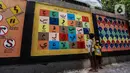 Anak-anak belajar mengenal huruf Arab melalui gambar mural di Jalan Pademangan 2, Jakarta, Senin (18/11/2019). Mural edukasi ini dikerjakan anak-anak muda yang tergabung dalam Tim Mural Pademangan Timur. (Liputan6.com/Faizal Fanani)