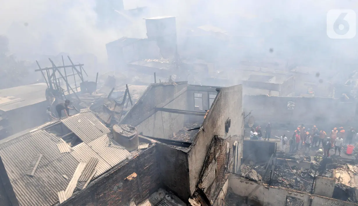 Petugas dibantu warga berusaha menjinakkan api yang melahap permukiman di Jalan Kebon Jeruk 13, Taman Sari, Jakarta Barat, Minggu (6/10/2019). Kebakaran menghanguskan puluhan rumah di dua kelurahan, Taman Sari dan Mapar. (merdeka.com/Iqbal Nugroho)