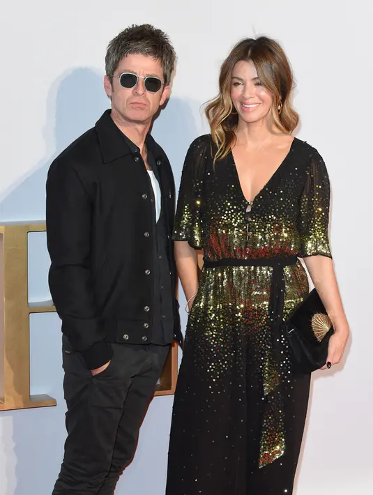 <p>Musisi Inggris Noel Gallagher (kiri) dan istrinya Sara MacDonald berpose di karpet merah saat tiba untuk pemutaran perdana film Inggris "A Star is Born" di pusat Kota London, Inggris, 27 September 2018. Hubungan sang mantan gitaris Oasis ini dengan istrinya akhirnya berakhir juga. (Anthony HARVEY/AFP)</p>