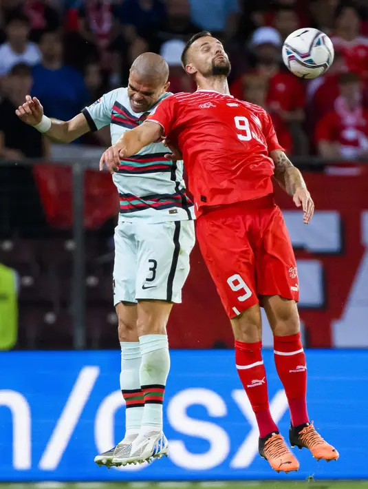 Pemain Portugal Pepe (kiri) berebut bola dengan pemain Swiss Haris Seferovic (kanan) pada pertandingan sepak bola Grup A2 UEFA Nations League di Stadion Stade de Geneve, Jenewa, Swiss, 12 Juni 2022. Portugal kalah tipis 0-1 dari Swiss. (Jean-Christophe Bott/Keystone via AP)